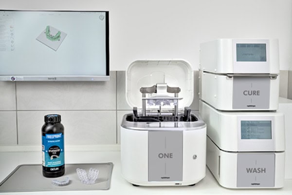 The ONE 3D Printing Solution, including the ONE wash and the ONE cure, RS Print Studio, and a dental resin bottle in a dental clinic.