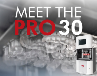 Image showing the PRO 30 with 3D Printed dentures and a background of its build platform with 3D printed surgical guides