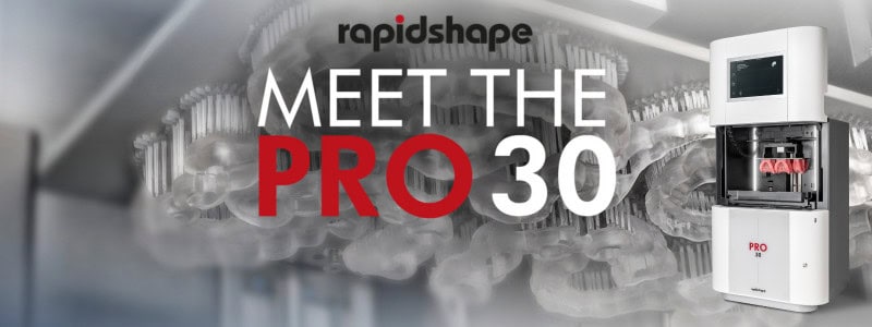 Meet the PRO 30 Image showing the PRO 30 with 3D Printed dentures and a background of its build platform with 3D printed surgical guides